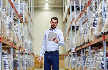 Image showing businessman with tablet pc at warehouse