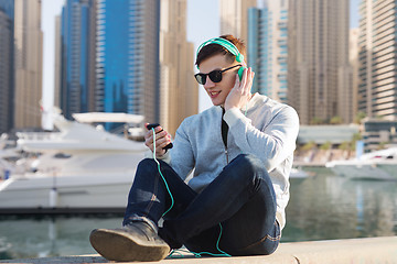 Image showing happy young man in headphones with smartphone