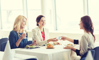 Image showing happy women giving birthday present at restaurant