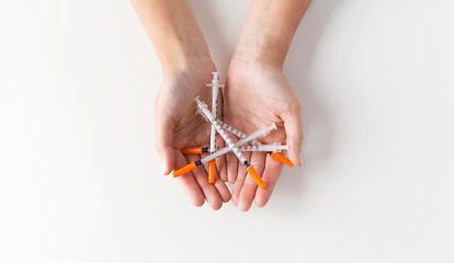 Image showing close up of woman hands holding syringes