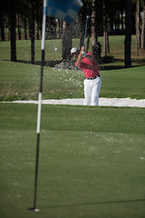 Image showing golfer hitting a sand bunker shot