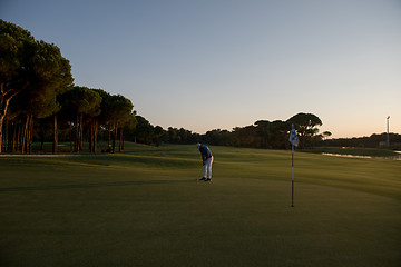 Image showing golfer hitting ball to hole