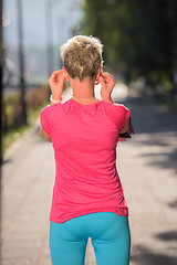 Image showing jogging woman setting phone before jogging