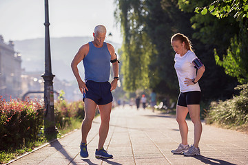 Image showing jogging couple planning running route  and setting music