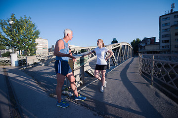 Image showing jogging couple planning running route  and setting music