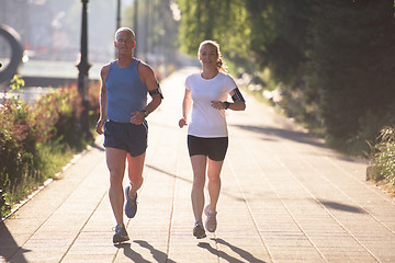 Image showing couple warming up and stretching before jogging