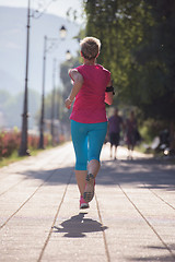 Image showing sporty woman running  on sidewalk