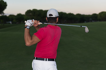 Image showing golfer hitting a sand bunker shot on sunset