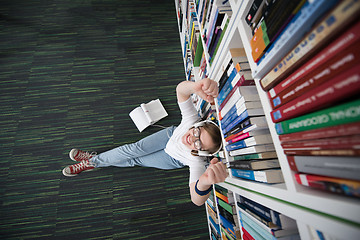 Image showing female student study in library, using tablet and searching for 