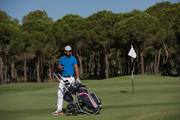 Image showing golf player walking with wheel bag