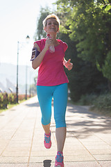 Image showing sporty woman running  on sidewalk