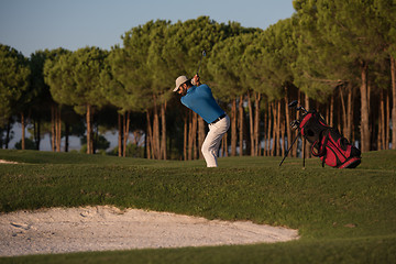 Image showing golfer hitting a sand bunker shot on sunset