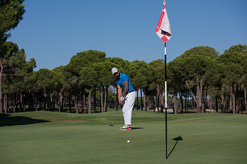 Image showing golf player hitting shot at sunny day