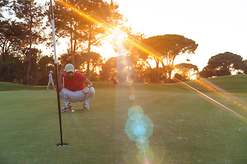 Image showing golf player aiming perfect  shot on beautiful sunset