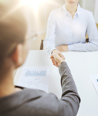 Image showing two calm businesswoman shaking hands in office