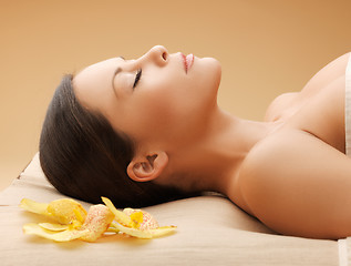 Image showing woman in spa salon lying on the massage desk