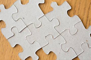 Image showing close up of puzzle pieces on wooden surface