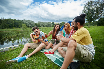 Image showing happy friends with drinks and guitar at camping