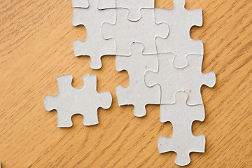 Image showing close up of puzzle pieces on wooden surface