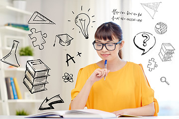 Image showing smiling young asian woman reading book at home