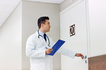 Image showing doctor with clipboard opening hospital ward door