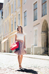 Image showing happy woman with shopping bags walking in city
