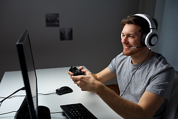 Image showing man in headset playing computer video game at home