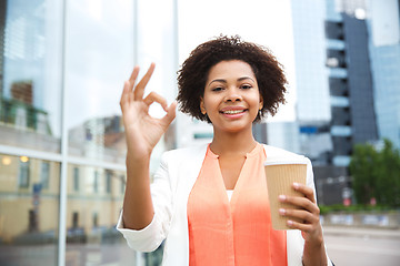 Image showing happy woman with coffee showing ok up in city