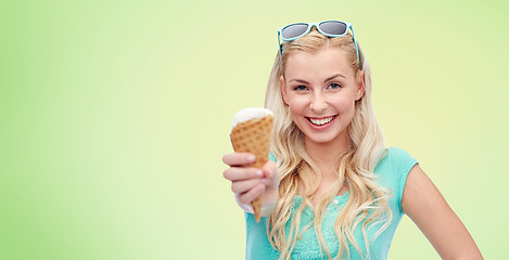 Image showing happy young woman in sunglasses eating ice cream