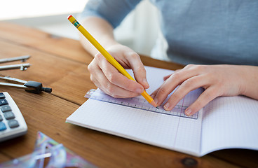 Image showing close up of hands with ruler and pencil drawing 