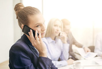 Image showing smiling business team with smartphones in office