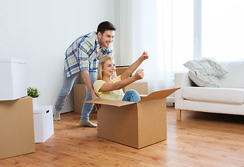 Image showing happy couple having fun with boxes at new home