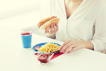 Image showing close up of woman eating hotdog and french fries