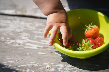 Image showing girl takes a strawberry