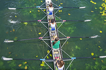 Image showing Four women rowing on the tranquil lake