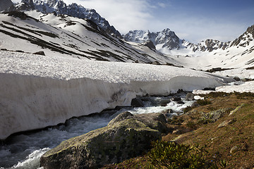 Image showing River with snow bridges in spring mountains at sun day