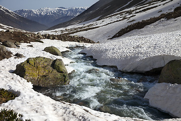 Image showing River with snow bridges in spring mountains at sun day