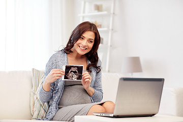 Image showing happy pregnant woman with ultrasound image at home