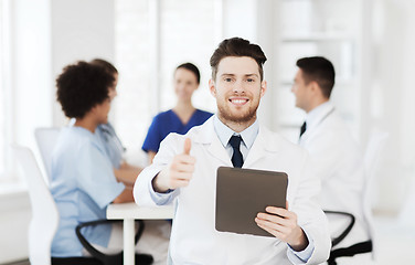 Image showing happy doctor with tablet pc over team at clinic