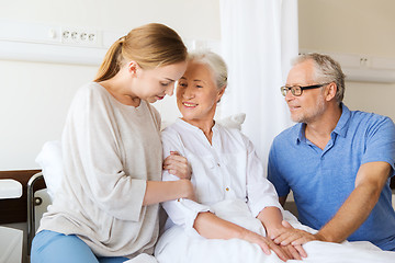 Image showing happy family visiting senior woman at hospital