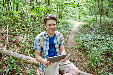 Image showing happy man with backpack and tablet pc in woods