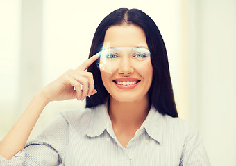 Image showing smiling woman pointing to futuristic glasses