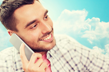 Image showing smiling young man calling on smartphone