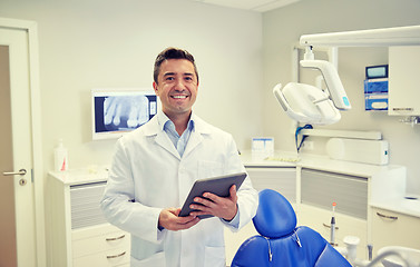 Image showing happy male dentist with tablet pc at dental clinic