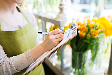 Image showing close up of woman with clipboard at flower shop