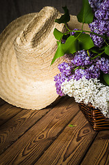 Image showing Still-life with a bouquet of lilacs and a straw hat, close-up