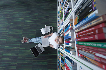 Image showing female student study in library, using tablet and searching for 