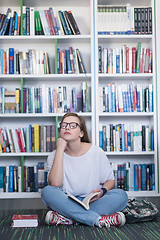 Image showing famale student reading book in library