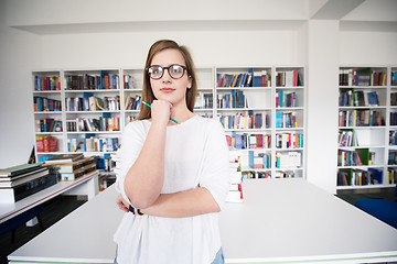 Image showing female student study in library, using tablet and searching for 