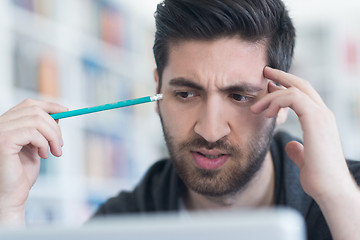 Image showing student in school library using laptop for research